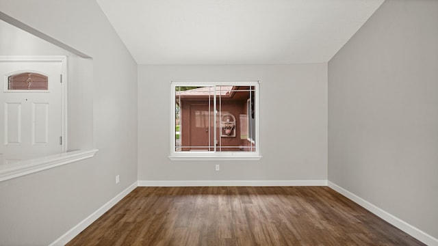 spare room featuring dark hardwood / wood-style floors and vaulted ceiling