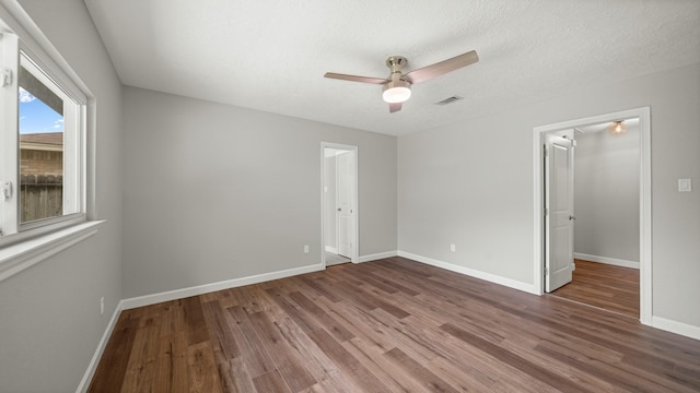 unfurnished room featuring ceiling fan, hardwood / wood-style floors, and a textured ceiling