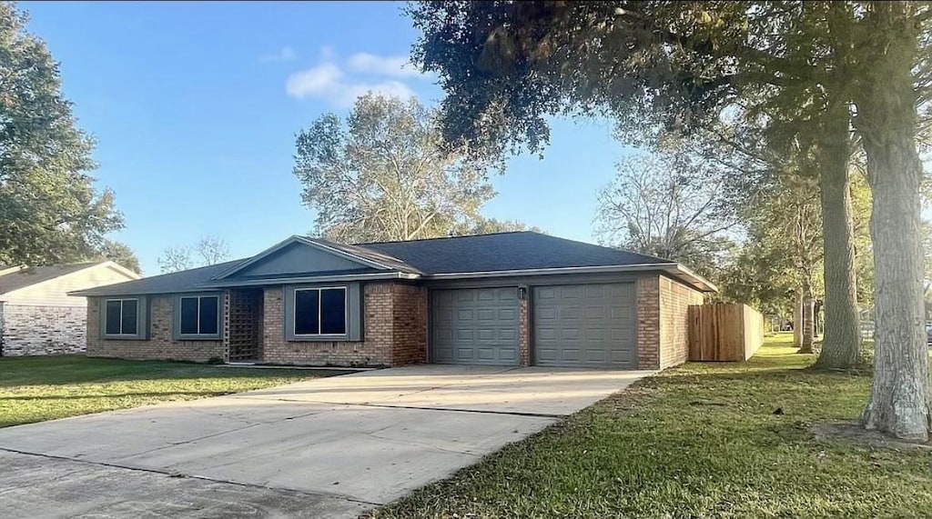 ranch-style home featuring a garage and a front lawn