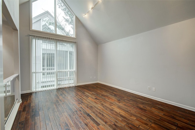 bonus room with dark wood-type flooring and a towering ceiling