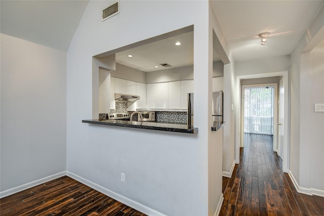 kitchen featuring white cabinets, exhaust hood, tasteful backsplash, dark hardwood / wood-style floors, and kitchen peninsula