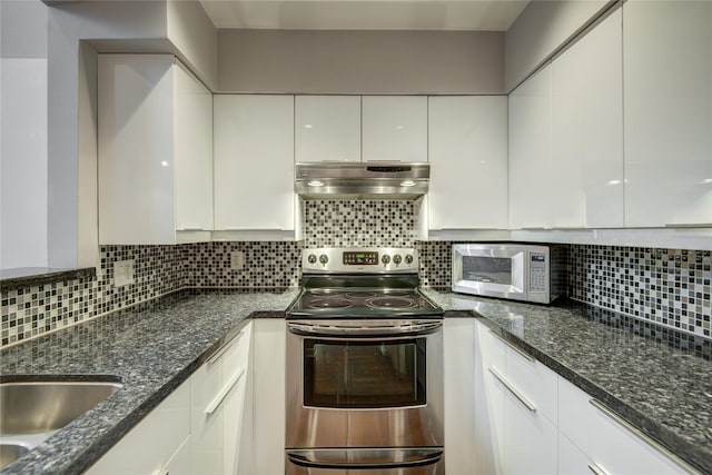 kitchen with dark stone countertops, stainless steel electric range oven, white cabinets, and tasteful backsplash