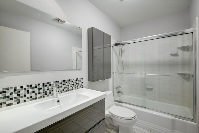 full bathroom featuring toilet, combined bath / shower with glass door, backsplash, and vanity