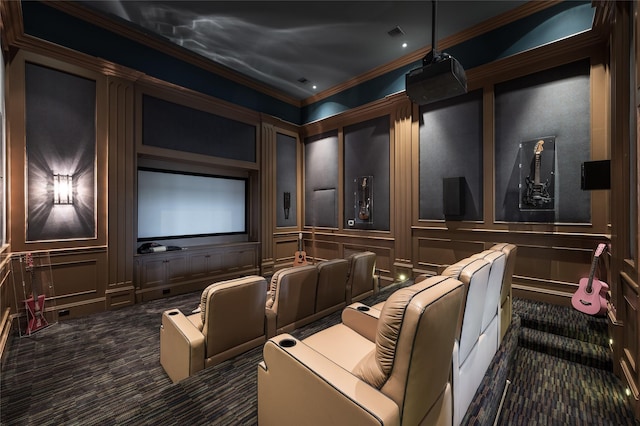 cinema room featuring ornamental molding and dark colored carpet