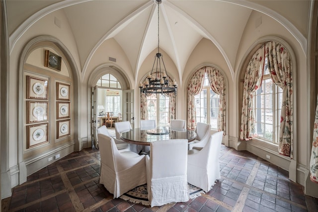 dining space with an inviting chandelier and vaulted ceiling