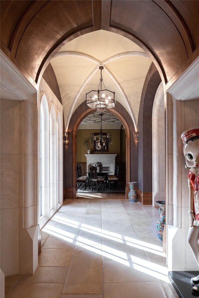 hallway with vaulted ceiling and a notable chandelier