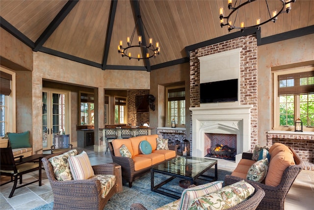 living room with high vaulted ceiling, wooden ceiling, an outdoor fireplace, beamed ceiling, and a notable chandelier