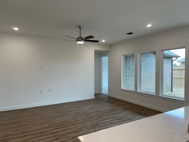 spare room with recessed lighting, dark wood finished floors, and baseboards