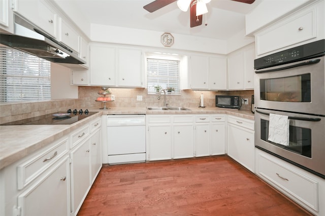 kitchen with ceiling fan, sink, black appliances, white cabinets, and light hardwood / wood-style floors