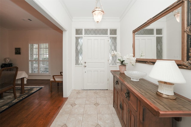 foyer entrance featuring light hardwood / wood-style flooring and ornamental molding