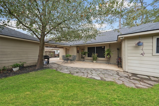 rear view of property with a patio and a lawn