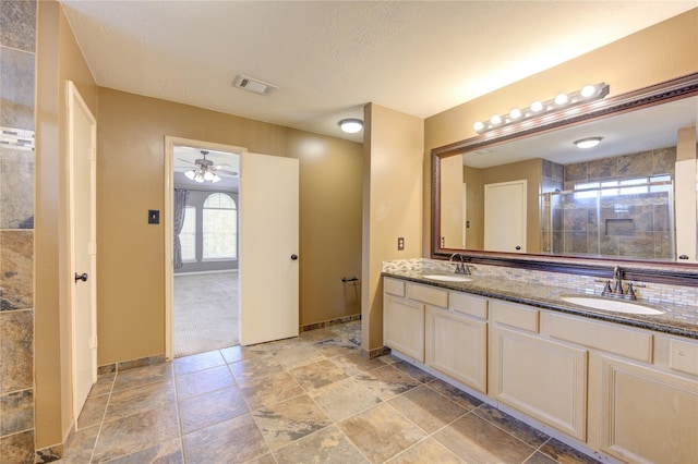 bathroom featuring a textured ceiling, vanity, ceiling fan, and walk in shower