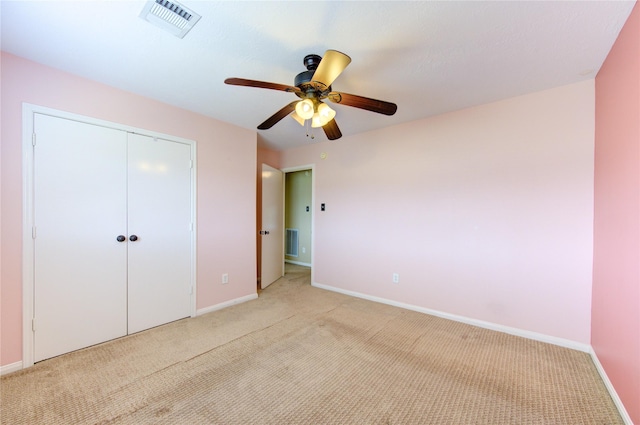 unfurnished bedroom with ceiling fan, light colored carpet, and a closet