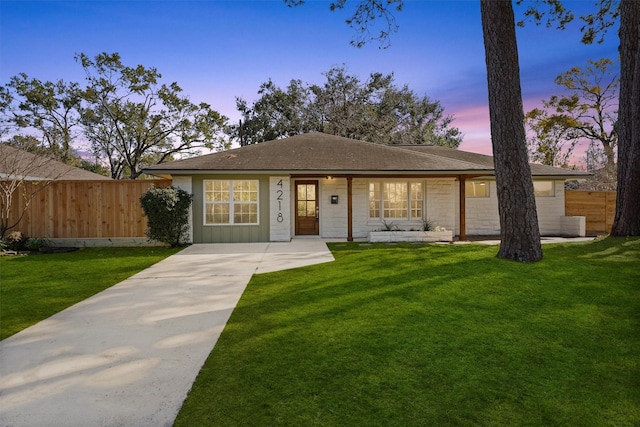 ranch-style home with a lawn