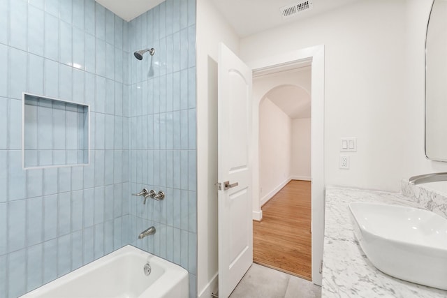 bathroom featuring tile patterned floors, vanity, and tiled shower / bath