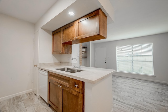 kitchen with kitchen peninsula, white dishwasher, a healthy amount of sunlight, and sink