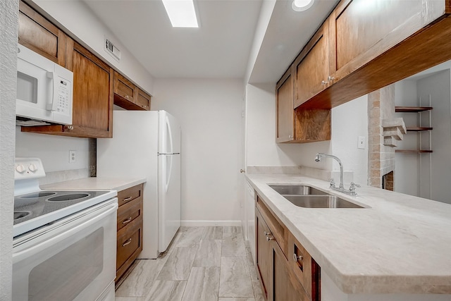 kitchen with kitchen peninsula, sink, and white appliances