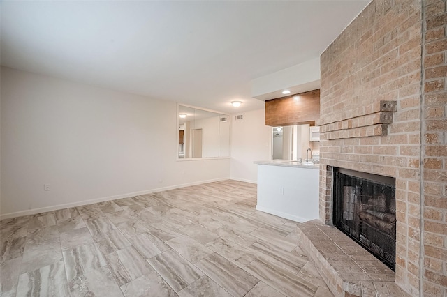 unfurnished living room featuring a brick fireplace