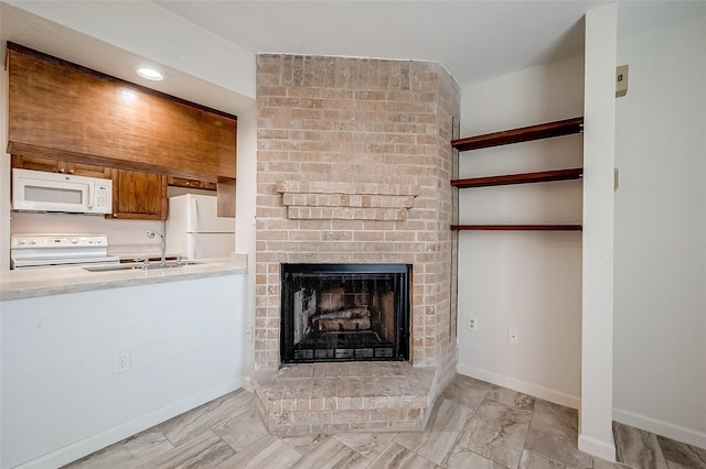 unfurnished living room featuring sink and a brick fireplace