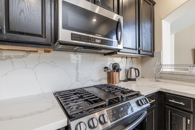 kitchen with gas stove, light stone countertops, and tasteful backsplash