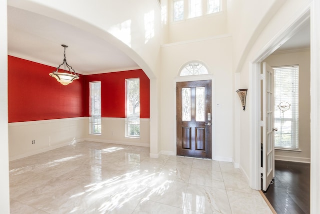 foyer entrance featuring a wealth of natural light and ornamental molding