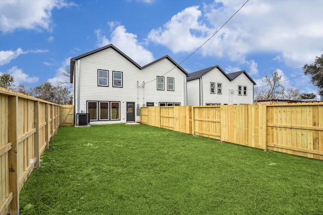 back of property featuring a lawn and central AC unit