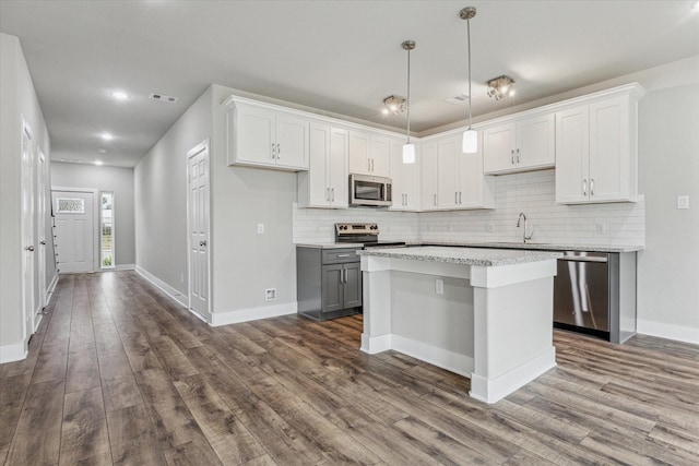 kitchen featuring white cabinetry, a center island, sink, and appliances with stainless steel finishes