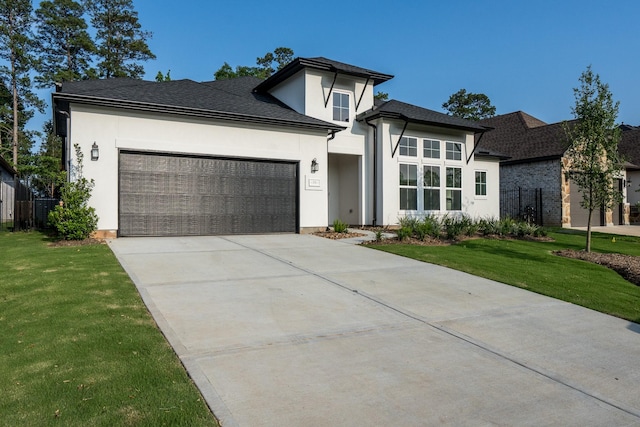 prairie-style home featuring a front yard and a garage