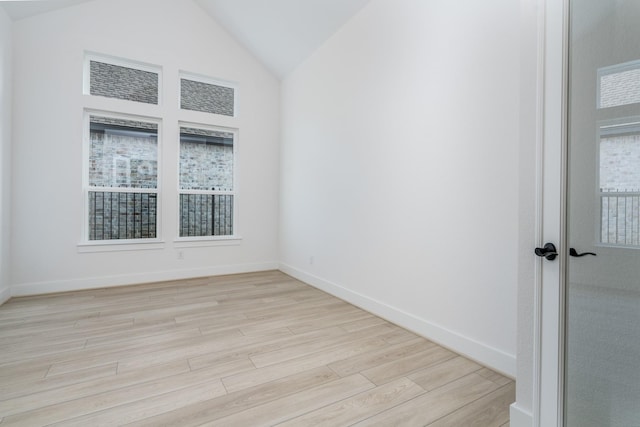 unfurnished room featuring light wood-type flooring and vaulted ceiling