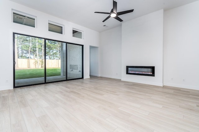 unfurnished living room featuring ceiling fan and light hardwood / wood-style flooring