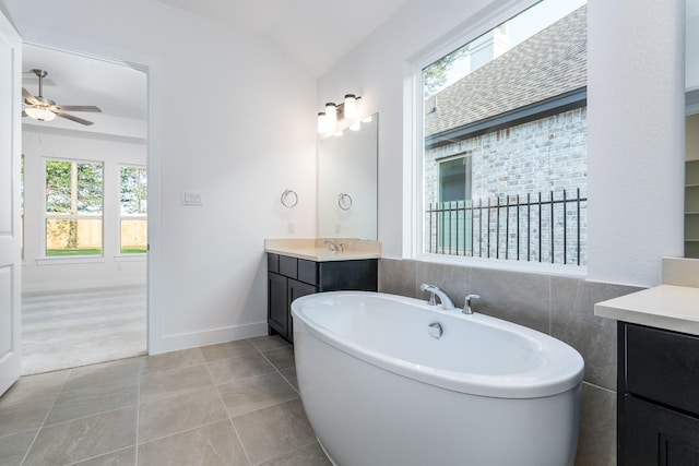 bathroom with a tub to relax in, vanity, ceiling fan, tile patterned flooring, and lofted ceiling