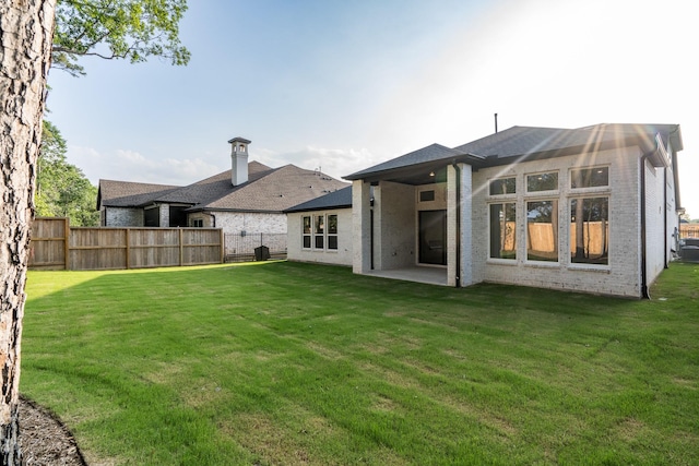 back of house featuring a lawn