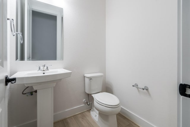 bathroom featuring hardwood / wood-style flooring and toilet