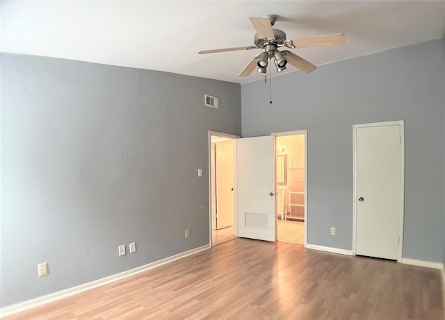 unfurnished bedroom with a high ceiling, light hardwood / wood-style floors, ensuite bath, and ceiling fan