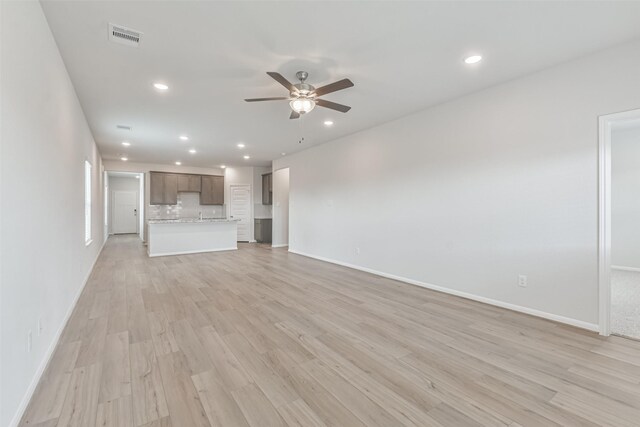 unfurnished living room with ceiling fan and light hardwood / wood-style floors