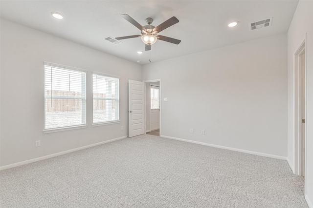 carpeted spare room with ceiling fan