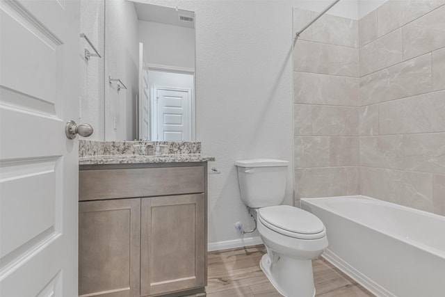 full bathroom with toilet, hardwood / wood-style floors, vanity, and bathing tub / shower combination