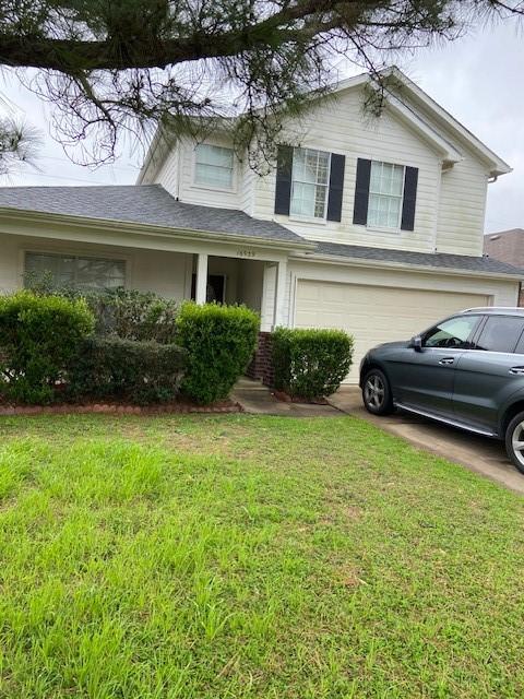 view of front facade with an attached garage, driveway, and a front yard