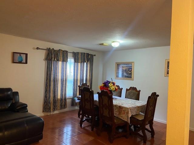 dining room featuring dark tile patterned floors and baseboards