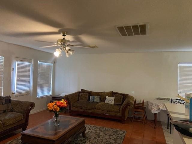 living area with visible vents, a ceiling fan, and wood finished floors