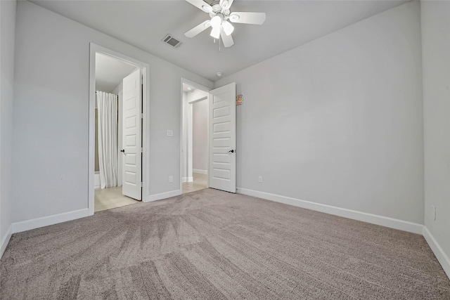 unfurnished bedroom featuring light carpet, ensuite bath, and ceiling fan