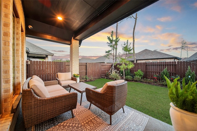 patio terrace at dusk with an outdoor hangout area and a yard