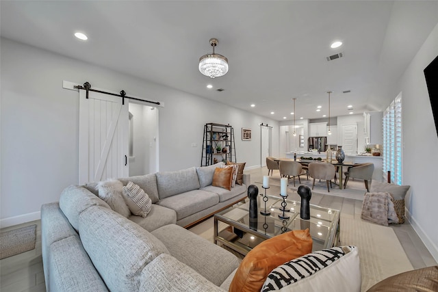 living room with a chandelier and a barn door