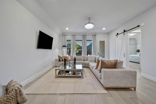 living room featuring a barn door and light hardwood / wood-style flooring