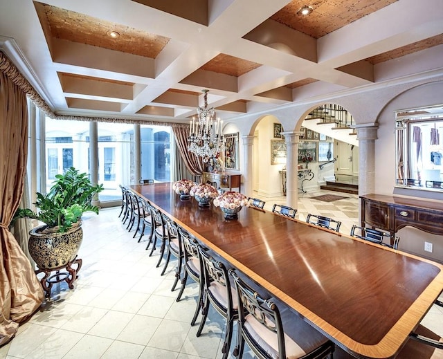 tiled dining area with coffered ceiling, a chandelier, beam ceiling, and decorative columns