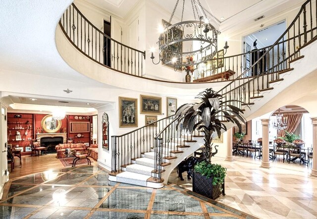 foyer entrance with a chandelier, a high ceiling, and crown molding