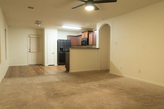 unfurnished living room with ceiling fan and light colored carpet