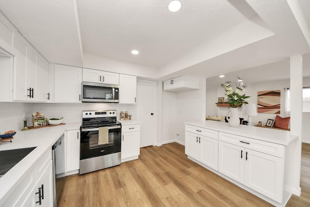 kitchen featuring backsplash, white cabinets, sink, appliances with stainless steel finishes, and light hardwood / wood-style floors