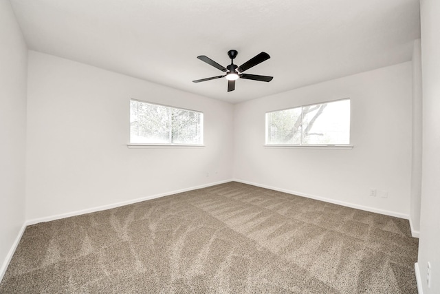 unfurnished room featuring a wealth of natural light, carpet floors, and ceiling fan