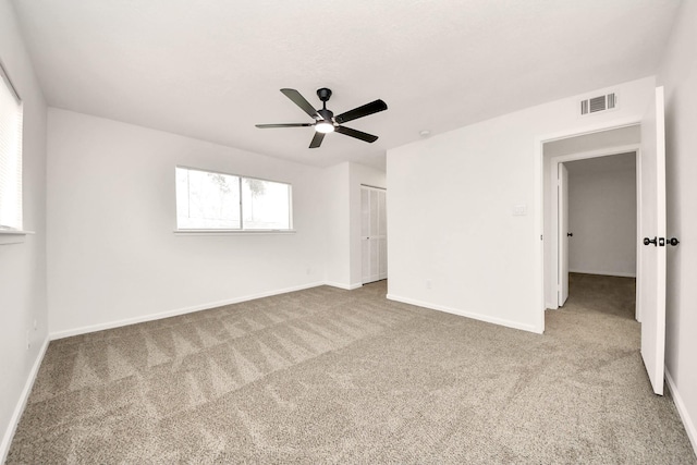 carpeted spare room with ceiling fan